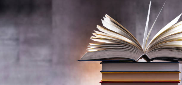 istock A composition with an open book lying on a stack of other books 1318423047