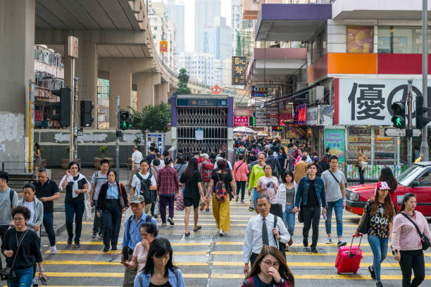 massen von fußgängern, die die straße in hongkong überqueren - hong kong billboard asia china stock-fotos und bilder
