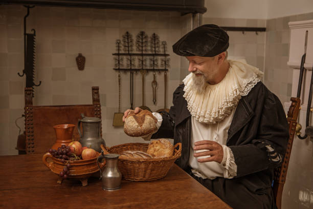 Portrait of a traditional dutch nobleman at a kitchen table Portrait of a handsome traditional dutch nobleman wearing historically correct outfit whilst sitting at a table in a typical townhouse kitchen neck ruff stock pictures, royalty-free photos & images