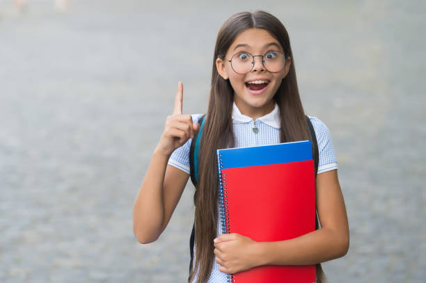 istock Got idea. Happy kid hold books keeping finger raised outdoors. Creative and innovative idea. Back to school. Creativity and innovation. Education is training mind to think 1318427763
