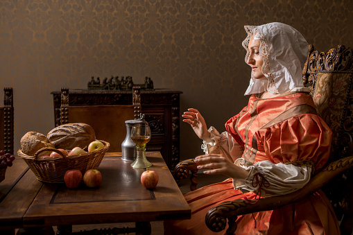 Portrait of a beautiful historical dutch noble woman wearing historically correct outfit in a typical townhouse