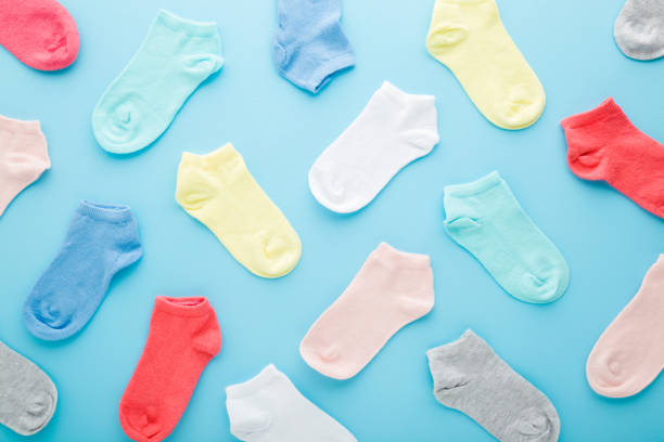 istock Many colorful kid short socks on light blue table background. Pastel color. Closeup. Clothes pattern. Top down view. 1318427775