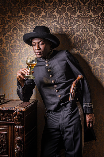 Handsome traditional dutch black man wearing historically correct outfit holding a gun in a typical townhouse drawing room