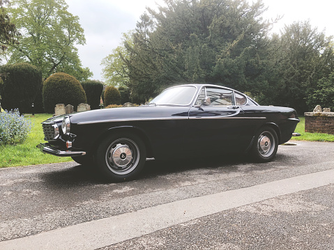 Beaconsfield, Buckinghamshire - May 17, 2021: A dark blue Volvo 1800S from 1967 parked up in the historic town of Beaconsfield in Buckinghamshire, UK.