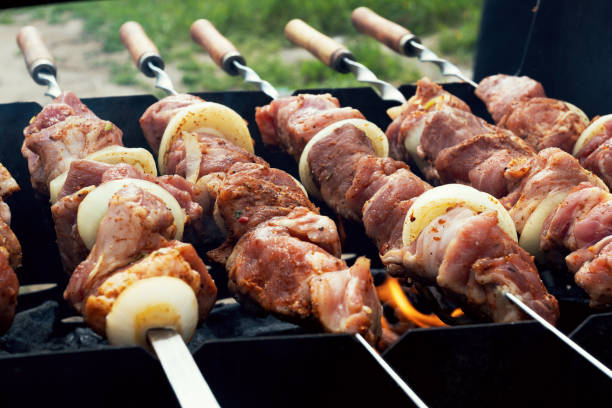 istock Marinated shashlik preparing on a barbecue grill over charcoal. Selective focus. Shashlyk (skewered meat) was originally made of lamb. Roast Beef Kebabs On BBQ Grill. 1318429706