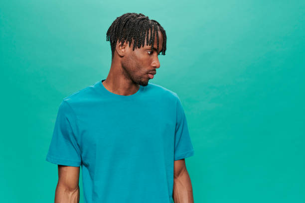 istock Young Black Wearing a blue t-shirt Over A Turquoise Background 1318430837