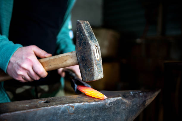 Forging hot iron Detail shot of hammer forging hot iron at anvil blacksmith shop photos stock pictures, royalty-free photos & images