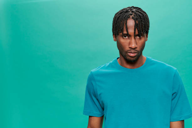 istock Young Black Wearing a blue t-shirt Over A Turquoise Background 1318430875