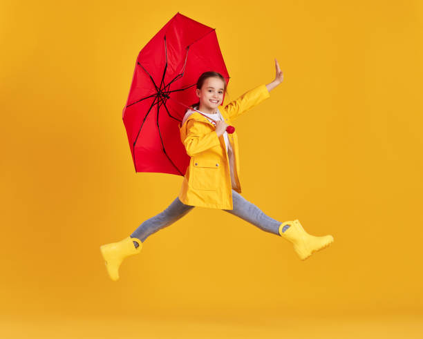 istock Happy kid with umbrella jumping in studio 1318431312