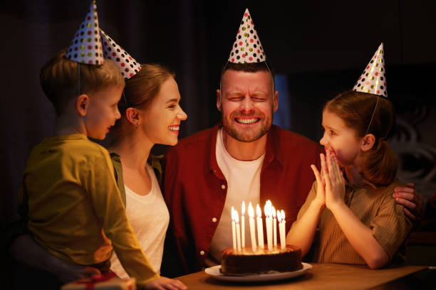 istock Young man father going to blow candles on chocolate cake while c 1318431443