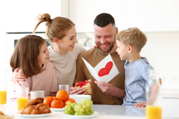 istock Mom with children congratulating dad with Fathers day while having breakfast in kitchen 1318433734