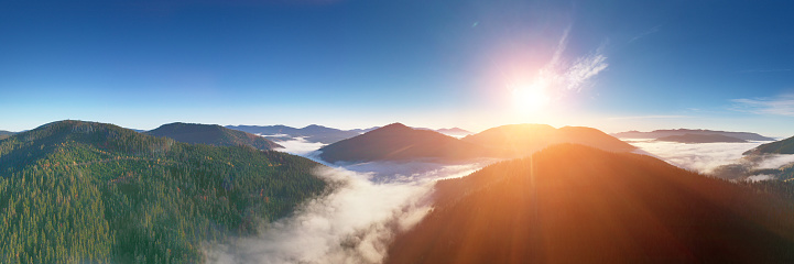 Fantastic view of the tops of the mountain ridge above the clouds at sunrise