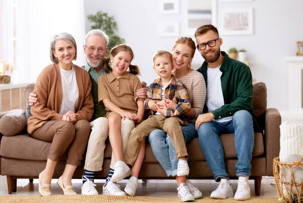 istock Beautiful multi generational family sitting together on couch at 1318434929