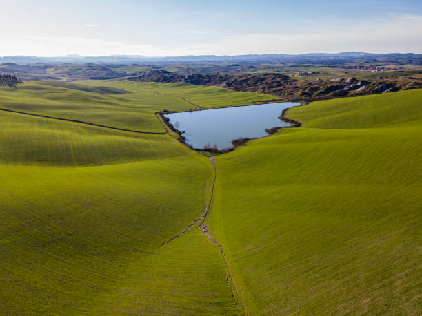 Idyllic green landscape ina clear day Aerial view of a dreamy countryside landscape in winter season with clear sky. Drone shot. crete senesi stock pictures, royalty-free photos & images