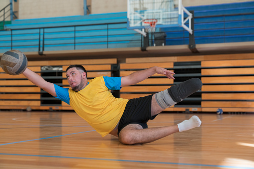 Disabled volleyball player making a great  pass while saving the ball.