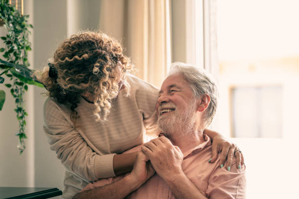 Portrait of bearded senior man looking at his middle-aged daughter, spending time together at home Portrait of bearded senior man looking at his middle-aged daughter, spending time together at home father and daughter stock pictures, royalty-free photos & images