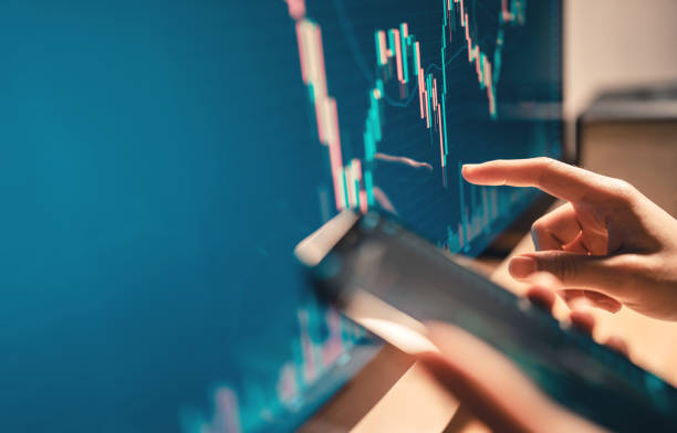 Hand of woman is checking Bitcoin price chart on digital exchange on computer, cryptocurrency future price action prediction.