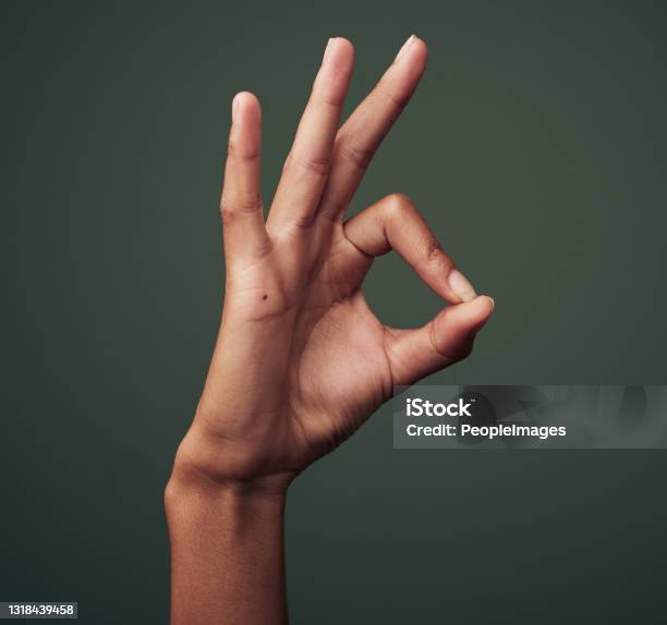 Studio Shot Of An Unrecognisable Woman Making An Okay Gesture Against A Green Background Stock Photo - Download Image Now