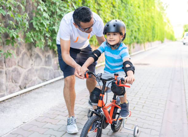 istock Father is teaching son to ride a bicycle 1318440329