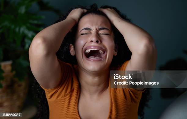 Shot Of A Young Woman Feeling Unhappy At Home Stock Photo - Download Image Now - Women, Shouting, One Woman Only