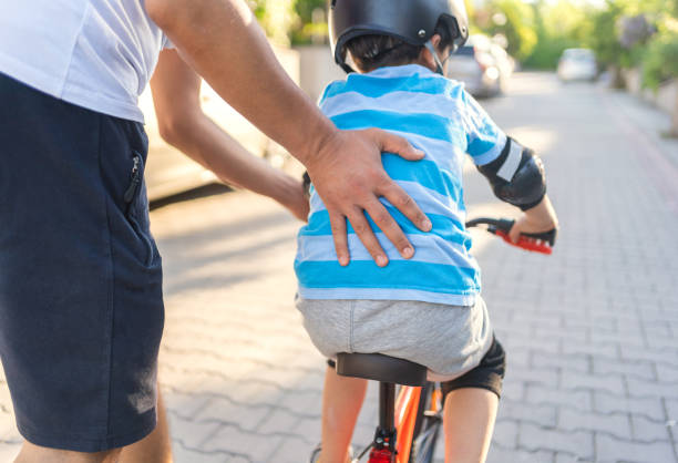 istock Father is teaching son to ride a bicycle 1318440377