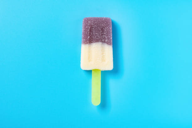 istock popsicle shape purple and white colors candy on blue background 1318441838