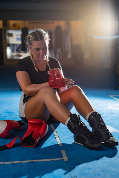 istock Female boxer wrapping her hands before a sports training 1318443108