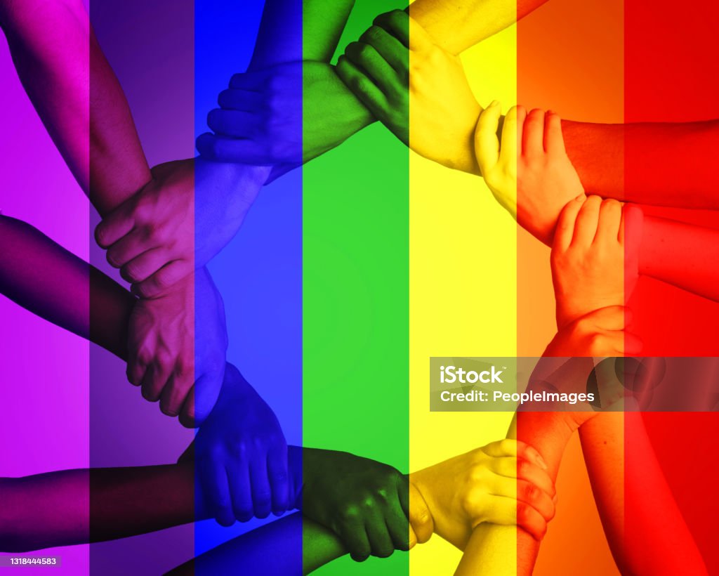 Cropped shot of unrecognizable people linking arms against a multi colored overlay This is a discrimination free zone Pride Stock Photo