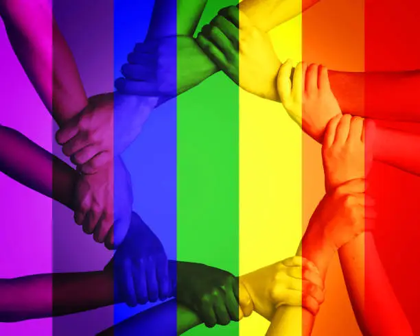 Photo of Cropped shot of unrecognizable people linking arms against a multi colored overlay