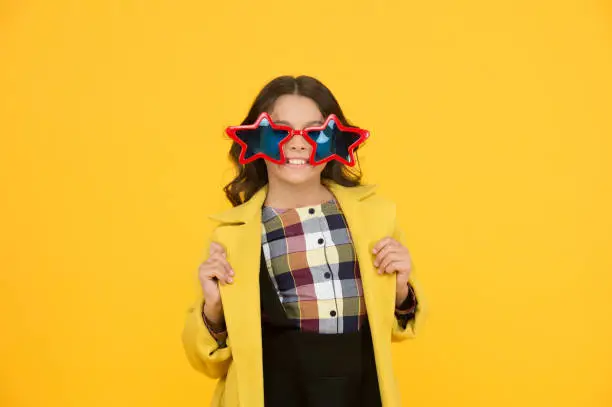 Photo of Rock star. Feeling like a superstar. Girl confident cool kid wear star shaped sunglasses. Star concept. Fame and popularity. Party holiday celebration. Cheerful girl wear eyeglasses for fun