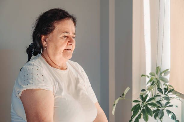 istock A lonely old woman looking out the window 1318445729