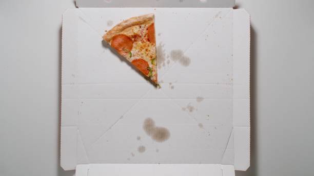 istock TOP VIEW: Last Piece of Pizza in The White Box on a table 1318447630