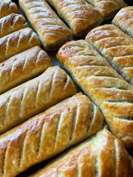 Full frame image of rows, golden brown, fresh crunchy sausage rolls, elevated view
