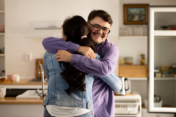 istock Happy interracial couple hugging and smiling at home 1318449052