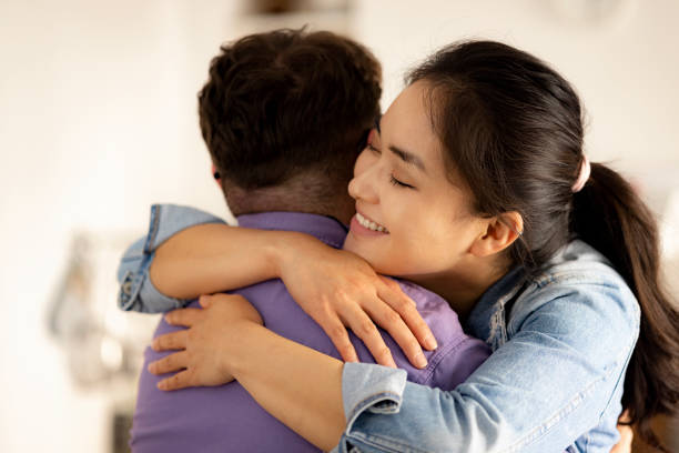 istock Happy interracial couple hugging and smiling at home 1318449436