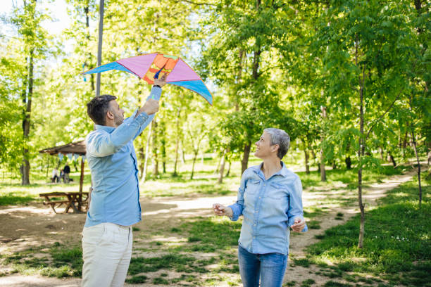 istock Man and woman having fun launching a kite in the park 1318449458