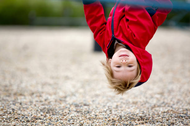 menino fofo, brincando no playground - school sport high up tall - fotografias e filmes do acervo