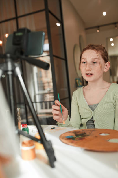 istock Girl drawing with acrylic paints while broadcasting for her blog about art 1318450525
