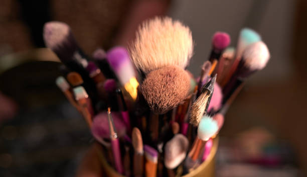istock Shot of makeup brushes in a container on a table backstage 1318450554