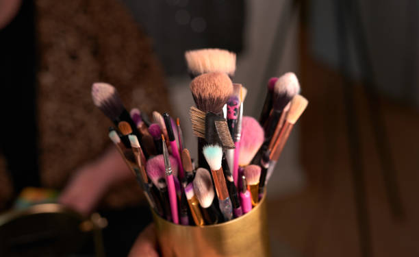 projectile des brosses de maquillage dans un récipient sur une table en coulisses - make up brush photos et images de collection