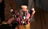 Shot of makeup brushes in a container on a table backstage
