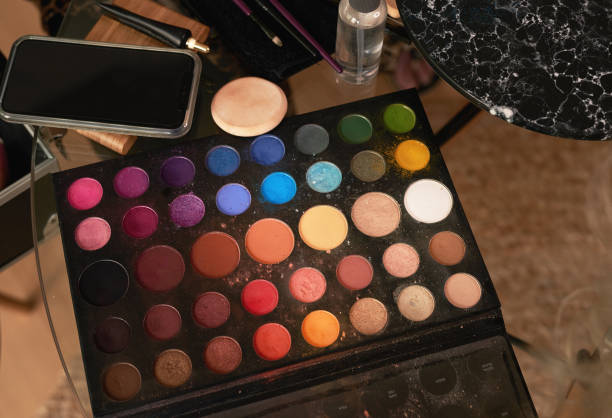 Shot of a makeup palette, smartphone and other tools on a table backstage