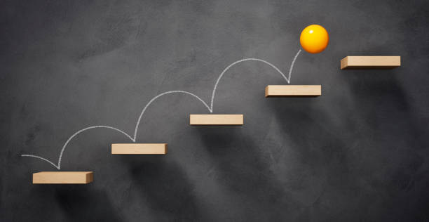 Jumping ball Thinking concept differently - new ideas Yellow ball jumping wooden stairway upwards with dark background - 3D illustration ladder of success stock pictures, royalty-free photos & images
