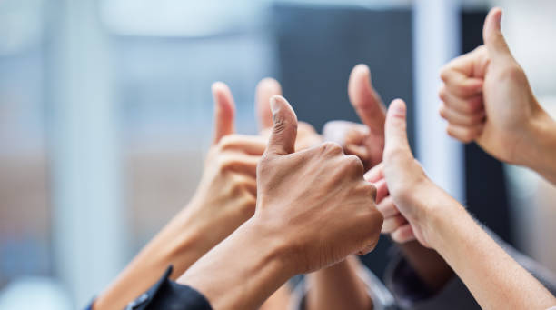 Shot of  a group of coworkers with their arms raised in the thumbs up gesture You're going to do great thumbs up stock pictures, royalty-free photos & images