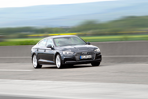 Weilbach, Germany - May 12, 2021: Audi A5 sportback on German highway A3 nearby Wiesbadener Kreuz. Audi A5 is a line of mid-size cars produced since 2007 by the German car manufacturer Audi. Audi AG is a German manufacturer of automobiles, the company is headquartered in Ingolstadt, Germany, and is a wholly owned subsidiary of Volkswagen AG.