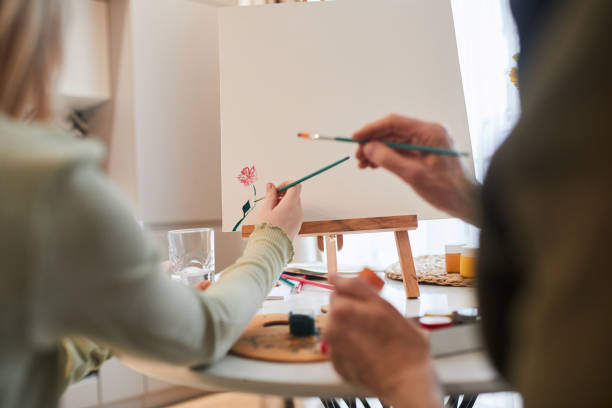 istock Kid drawing with paints while her grandmother sitting near 1318453346