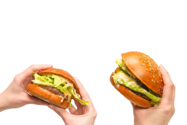 istock Hamburger in woman hands isolated on a white background. 1318456878
