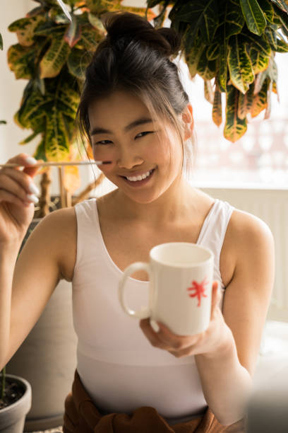istock Attractive woman looking at the camera while painting at home 1318457326