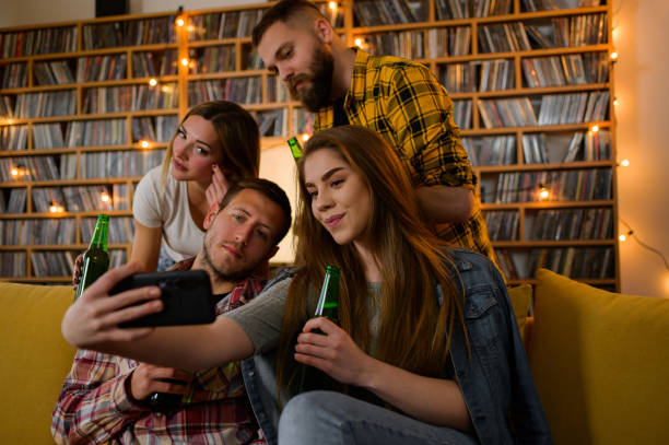 istock Friends a house party and taking selfie with a smartphone while drinking beer 1318457601