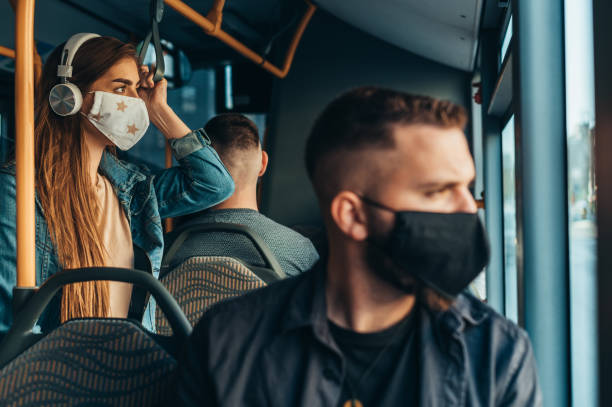 man wearing a protective mask while riding the bus while sitting on a distance - bus riding public transportation businessman imagens e fotografias de stock